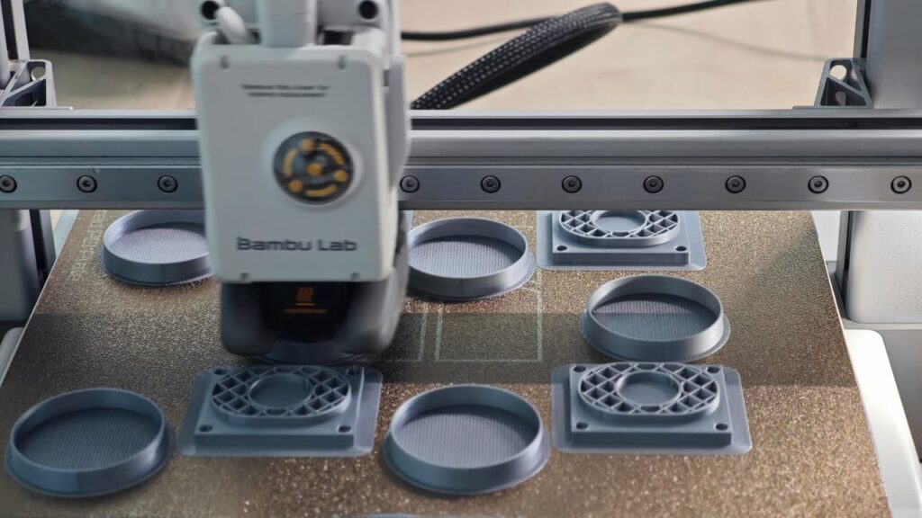 Industrial 3D printer creating prototype parts and custom models.
